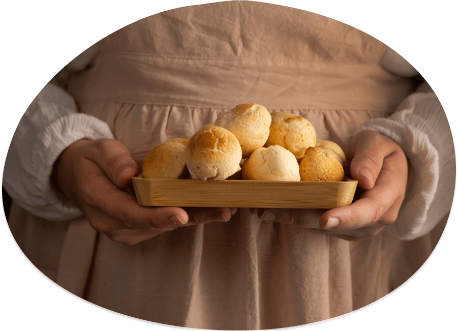 Cozinheira com uma bandeja com pães de queijo